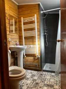 y baño con aseo, lavabo y ducha. en Corner Hostel Puerto Natales, en Puerto Natales