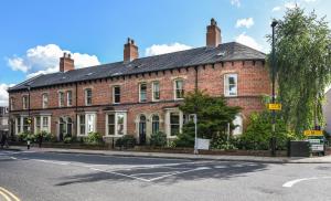 a large brick building on the corner of a street at 3-Bedroom Lower Ground Flat in Knaresborough Town Centre in Knaresborough