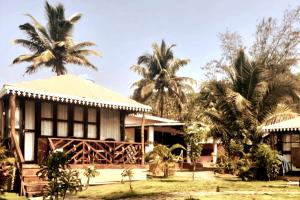 a house with palm trees in front of it at Neelchand in Canacona