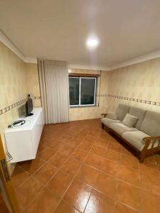 a living room with a couch and a tv at Casa da Leonor in Viseu