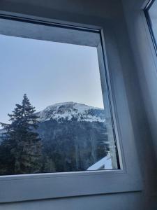 a window with a view of a snow covered mountain at Chalet Jaune Charmant SOM in Sarcenas