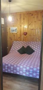 1 dormitorio con 1 cama con pared de madera en Casetta Maia, en Lavarone