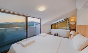 a bedroom with a large bed and a large window at Villa Neo with 2 private pools, bbq, jacuzzi and sauna in Fethiye