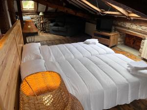 Casa Rural Basiver - Suite Basiver في Armaño: سرير أبيض كبير في غرفة مع أريكة