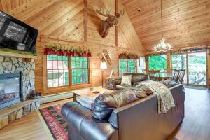 a living room with a leather couch and a fireplace at Cozy Gore Mountain Cabin with Game Room and Fire Pit in North Creek