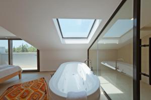 a bathroom with a bath tub and a skylight at Villa Neo with Jakuzi,indoor pool,sauna and floor heating in Fethiye