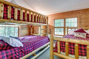 a bedroom with two bunk beds in a log cabin at Cozy Gore Mountain Cabin with Game Room and Fire Pit in North Creek