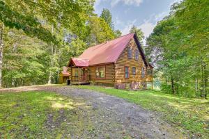 una cabaña de madera en el bosque con un camino de tierra en Cozy Gore Mountain Cabin with Game Room and Fire Pit en North Creek