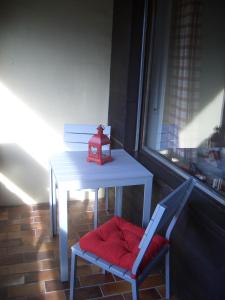 ein Tisch und ein Stuhl neben einem Tisch mit einer Uhr drauf in der Unterkunft Ferienwohnung Franziska in Garmisch-Partenkirchen
