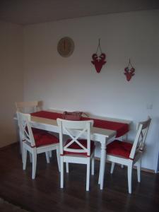 einen Esstisch mit 2 Stühlen und einen weißen Tisch mit roten Kissen in der Unterkunft Ferienwohnung Franziska in Garmisch-Partenkirchen