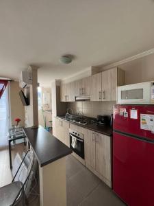 比亞里卡的住宿－Departamento en Villarrica，厨房配有红色冰箱和台面
