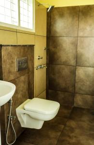a bathroom with a toilet and a sink at ADONAY INN RESIDENCY in Kalpetta