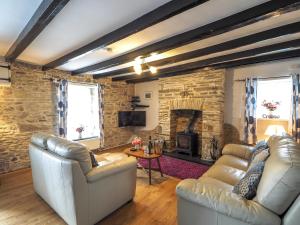 a living room with two couches and a fireplace at Y Bwthyn in Tal-gareg