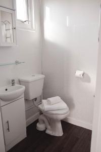 a white bathroom with a toilet and a sink at Immaculately Presented Detached Family Chalet - 5 mins to beach, nr Great Yarmouth & Norfolk Broads in Great Yarmouth