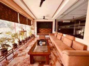 een woonkamer met een bank en een salontafel bij Tirath View Central Hotel - A Comfortable Stay in Haridwār
