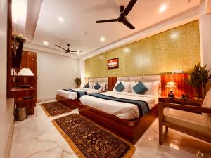 Tirath View Central Hotel - A Comfortable Stay في حاريدوار: غرفة نوم بسريرين ومروحة سقف