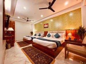 a bedroom with two beds and a ceiling fan at Tirath View Central Hotel - A Comfortable Stay in Haridwār