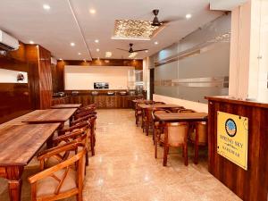 Tirath View Central Hotel - A Comfortable Stay في حاريدوار: غرفة طعام مع طاولات وكراسي خشبية