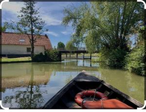 um barco está na água em um rio em Le Petit Paradis de Noordpeene em Noordpeene