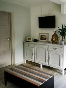 a room with a white cabinet with a tv on the wall at Le Petit Paradis de Noordpeene in Noordpeene