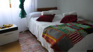 a bedroom with a bed with a colorful blanket on it at Casa Porto dos Barcos in Pedornes