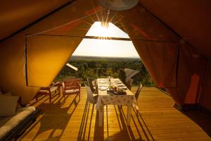 a table and chairs in a tent with a view at Glamping Grancia in Grosseto