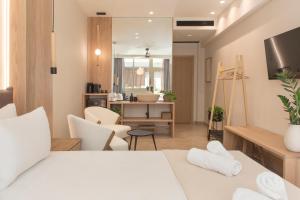 ein Schlafzimmer mit einem Bett und ein Wohnzimmer in der Unterkunft Living Stone Condo Hotel in Athen