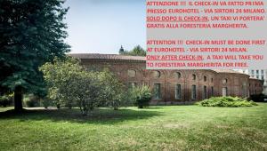 ceglany budynek z drzewem przed nim w obiekcie Guesthouse Foresteria Margherita Milano w Mediolanie