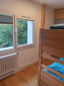 a bedroom with a bunk bed and two windows at Chalet Jaune Le GRAND SOM in Sarcenas