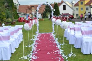 une rangée de tables et de chaises blanches avec un couloir rouge et blanc dans l'établissement Penzion u Bláhů, à Dolany