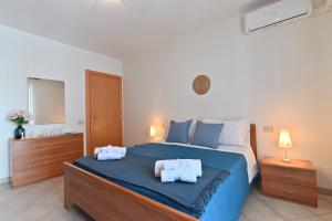 a bedroom with a large bed with towels on it at IzzHome Lemon Tree in Pula