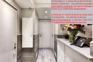 eine Küche mit einem Telefon und Blumen auf dem Tresen in der Unterkunft Guesthouse Foresteria Margherita Milano in Mailand