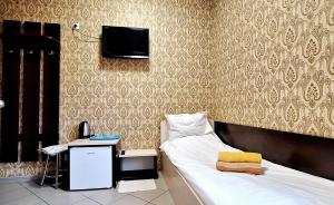 1 dormitorio con 1 cama, escritorio y TV en Lisova - Лісова готельня і сауна en Kiev