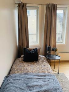 1 dormitorio con cama con almohada y mesa en Moderne leilighet i sentrum av Sandefjord, en Sandefjord