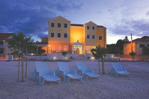 a group of blue chairs in front of a building at Hotel Spongiola in Krapanj