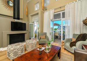 a living room with a fireplace and a tv at Canal Waterside Lifestyle on Thesen Islands in Knysna