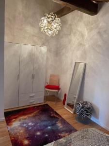 a room with a mirror and a chair and a chandelier at Ferienwohnung und Zimmer "do is schee" in Blaibach