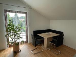 a small table and chairs in a room with a window at Ferienwohnung "do is schee" in Blaibach