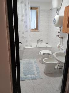 a bathroom with a toilet and a tub and a sink at B&B La casa dell'ospite in Gravina in Puglia +12 photos