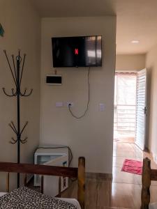 um quarto com uma televisão pendurada na parede em Aloha Oe Itaguá em Ubatuba