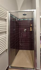 una doccia con porta in vetro in bagno di ll Covo del Brigante a Melfi
