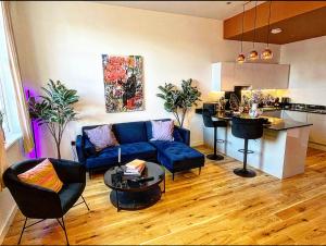sala de estar con sofá azul y cocina en Dusk House - Wyndale Living - B'ham JQ Townhouse, en Birmingham