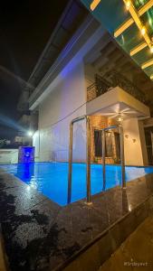 a swimming pool at night in a building at Mystic Dreamville 3BHK Villa Lonavala in Lonavala