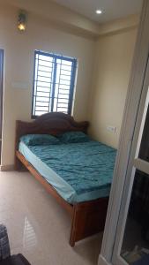 a small bedroom with a bed with a window at YETTI-A GUEST HOUSE in Yercaud