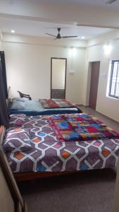 1 dormitorio con 1 cama grande y edredón colorido en YETTI-A GUEST HOUSE, en Yercaud