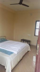 a bedroom with a bed and a ceiling fan at YETTI-A GUEST HOUSE in Yercaud