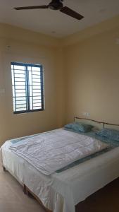 1 cama en un dormitorio con ventilador de techo en YETTI-A GUEST HOUSE, en Yercaud