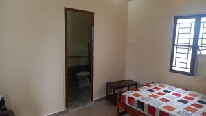 a bedroom with a bed and a window and a mirror at YETTI-A GUEST HOUSE in Yercaud