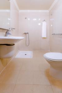 a white bathroom with a sink and a toilet at Hôtel Lynx in Agadir