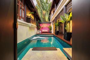 een zwembad in het midden van een gebouw bij Bangkok CBD Pinky Vibe Villa in Bangkok